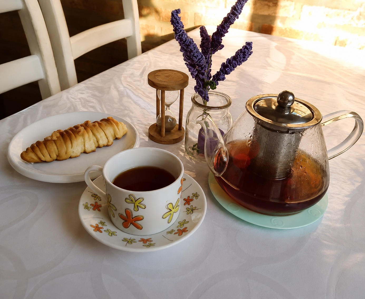 Merienda de campo en MAMU Casa de Té — tetera de vidrio con té, pastel artesanal, reloj de arena y lavanda